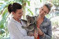 Deux femmes câlinent un koala