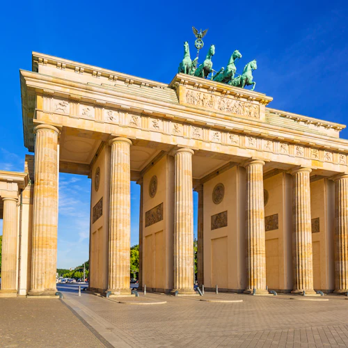 Brandenburger Tor i Berlin, med sex pelare, en staty med en vagn på toppen, under en klarblå himmel.
