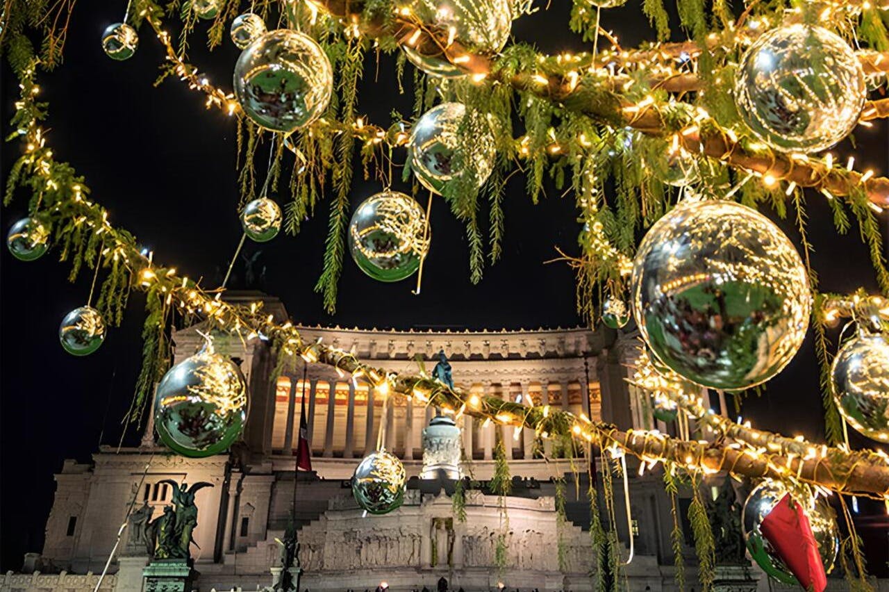 夜、壮大な建物の前に金色のライトと反射飾りで照らされたクリスマスの装飾。