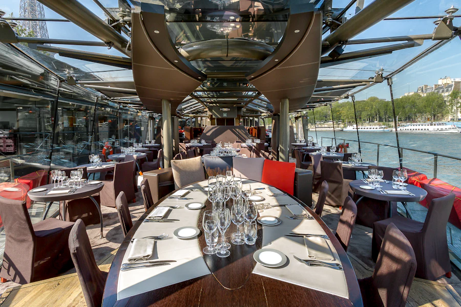 Elegant glazen restaurantboot met gedekte tafels en uitzicht over de Seine