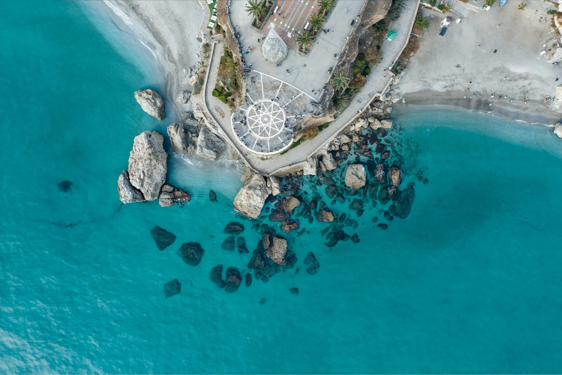 Aerial view of the iconic lookout over the sea, surrounded by rocks and turquoise waters.