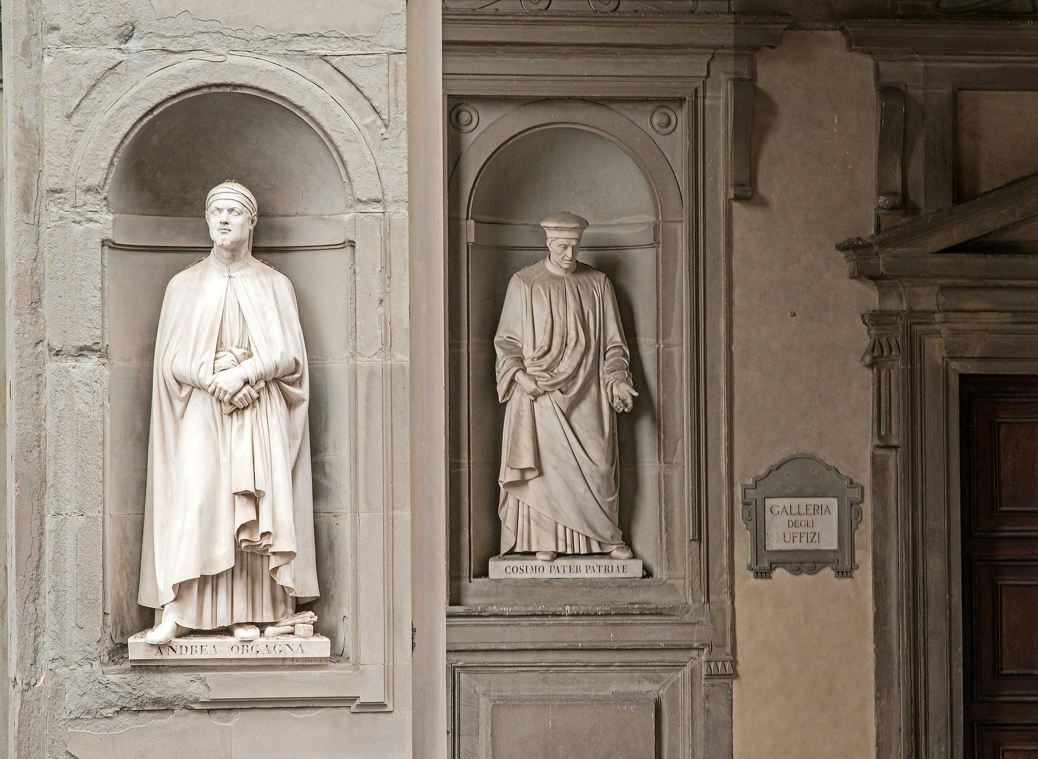 Two marble statues of men in robes are set in alcoves on a stone wall. One statue is labeled "ANDREA ORCAGNA," the other "COSMO PINI PATER."