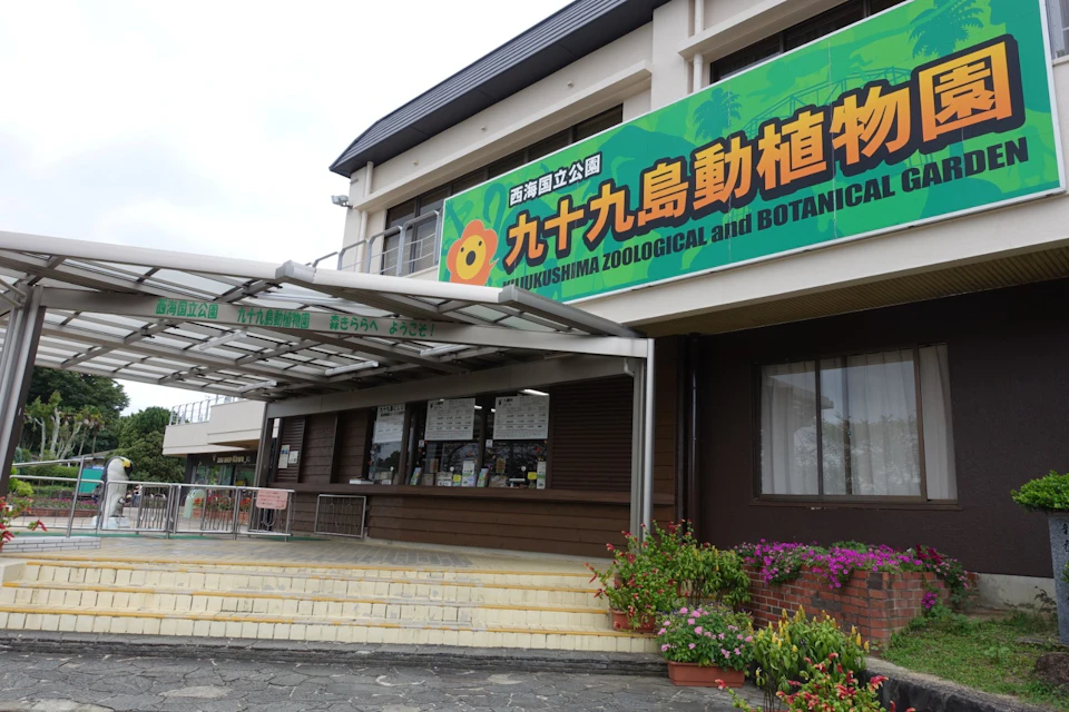Entrance of Kujukushima Zoological and Botanical Garden with a large green sign above.