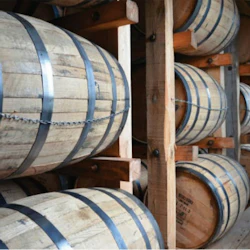 Träfat staplade i rader på träställ i ett lager eller förvaringsutrymme.