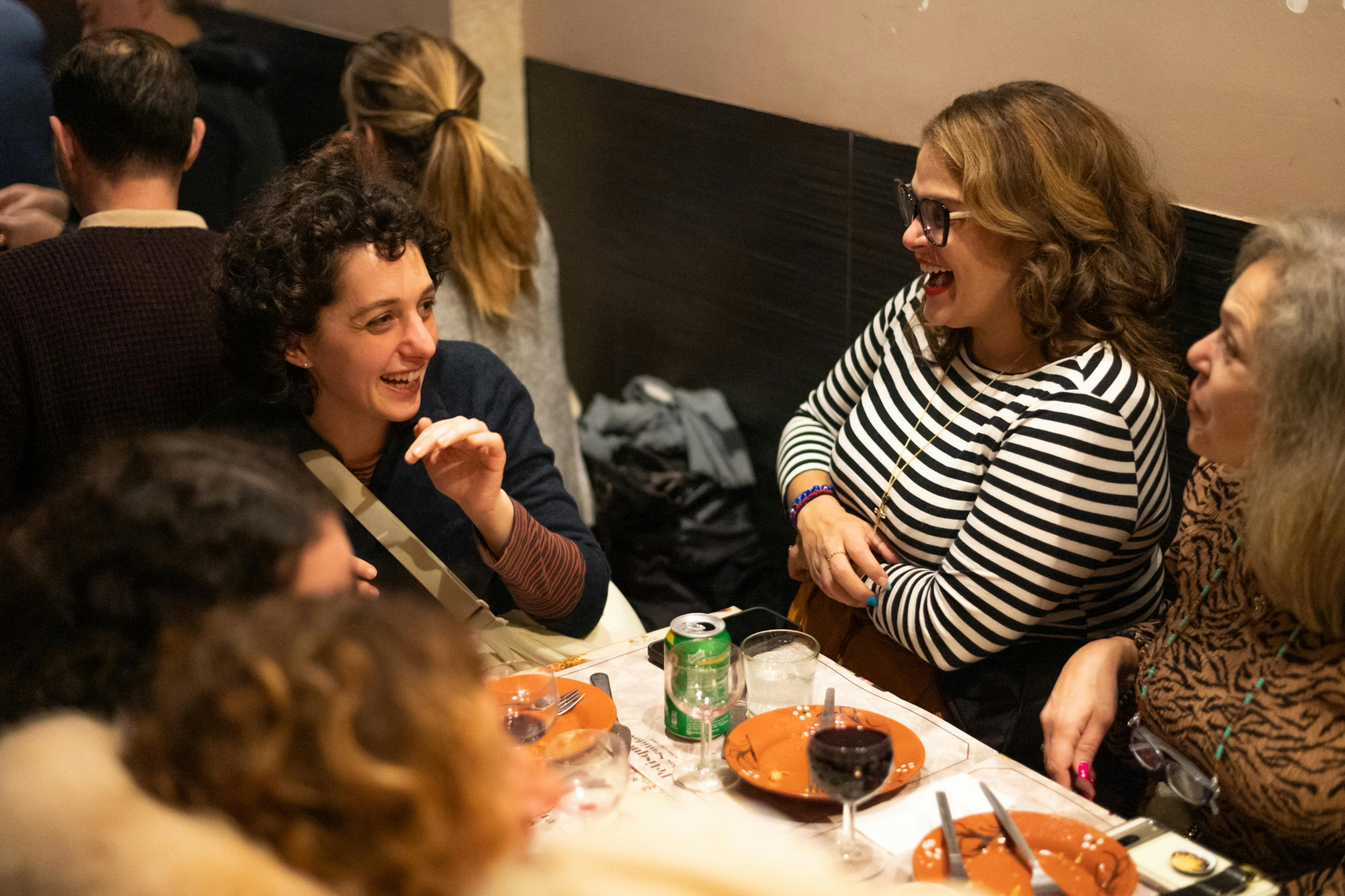 Amici che si godono cibo, bevande e risate in un ambiente vivace