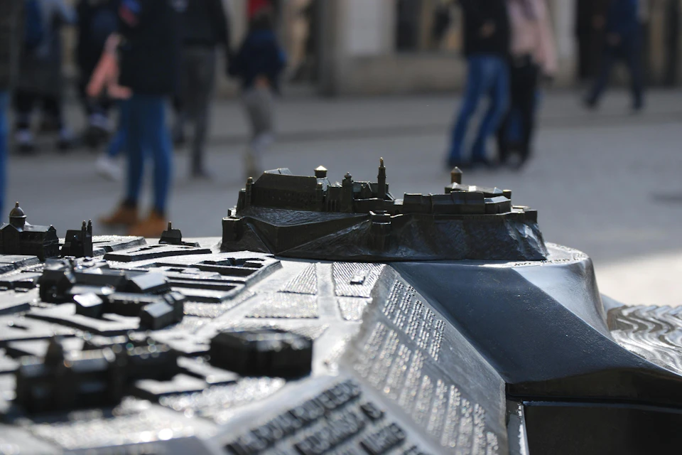 A tactile model of a historic site with people walking in the background.