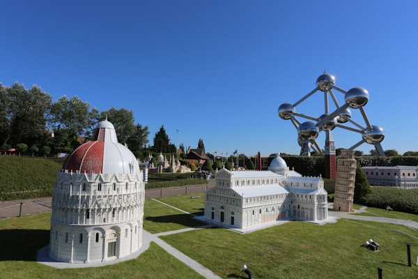 Maquetes en miniatura de famosos edificis i llocs emblemàtics europeus situats en un parc paisatgístic, amb l'estructura Atomium al fons.