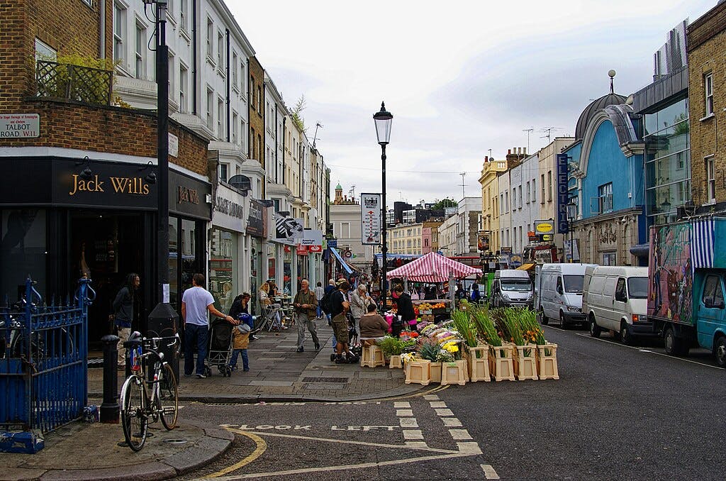 Tętniący życiem uliczny targ z stoiskami z kwiatami, sklepami i witrynami sklepowymi.