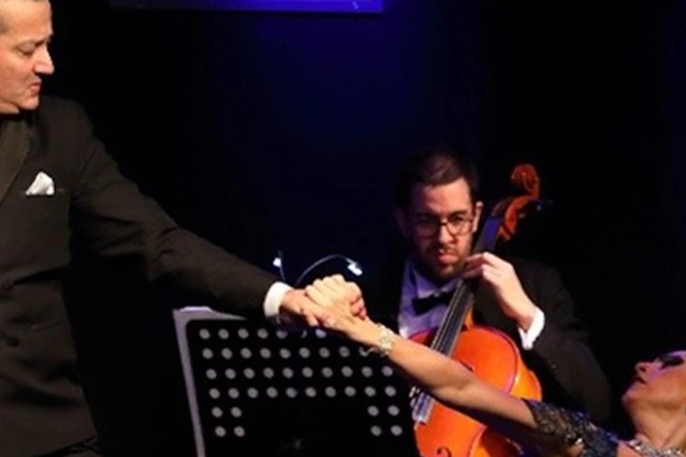 A tango couple sways gracefully on stage, their passion igniting the air, while a soulful cello adds depth to the dance.