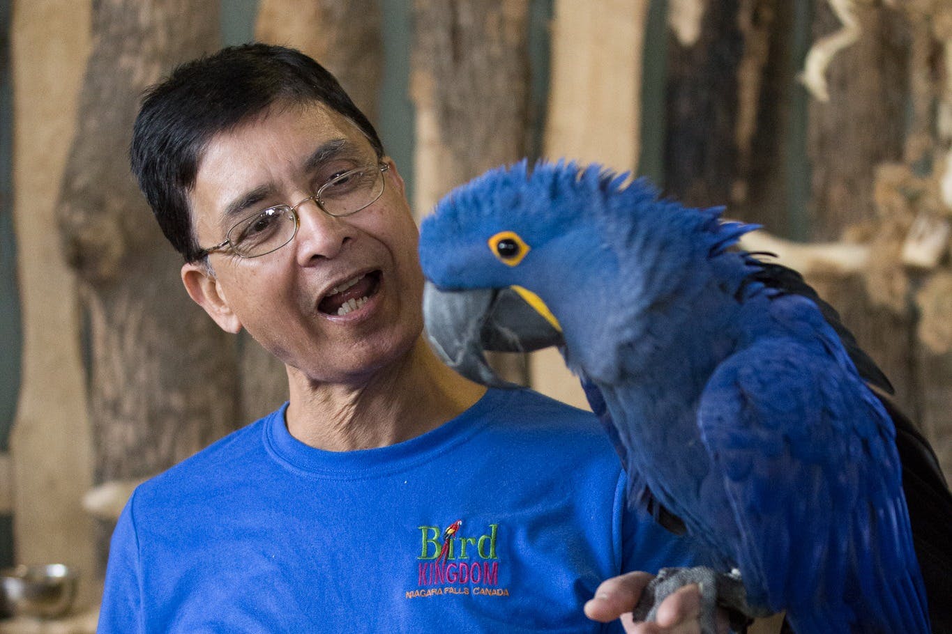 손에 히아신스 마코 앵무새를 들고 있는 남성