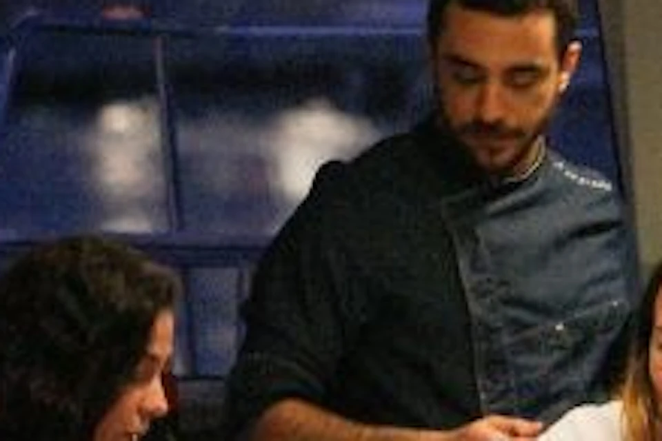 A group of people are gathered around the table, enjoying dinner on board the catamaran.