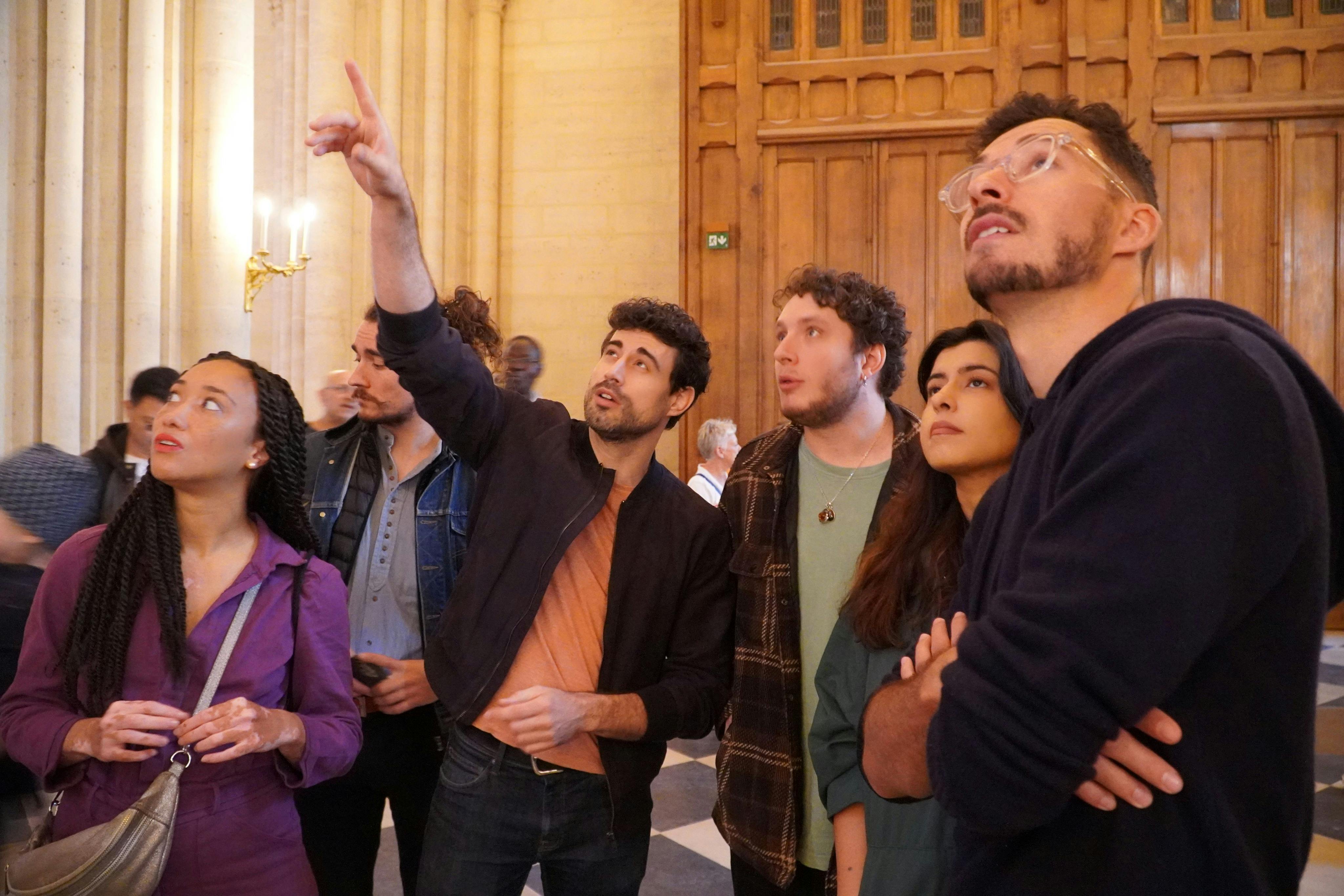 The supplier guides and points out details inside Notre Dame Cathedral.