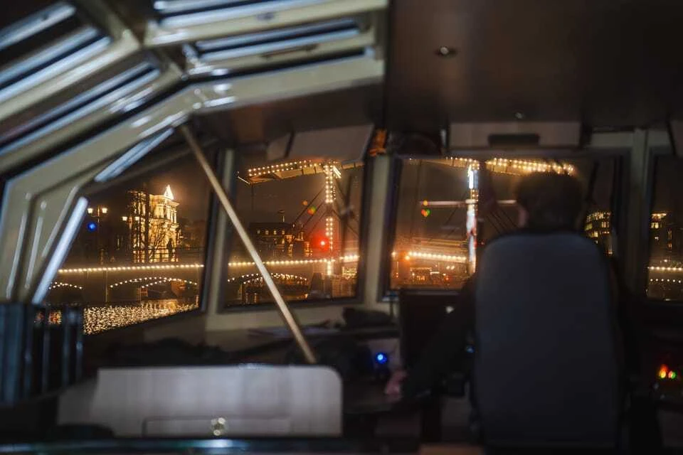 The interior of a boat with the Magere Brug approaching from the front