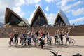 Ciclisti in posa davanti al teatro dell'opera di Sydney