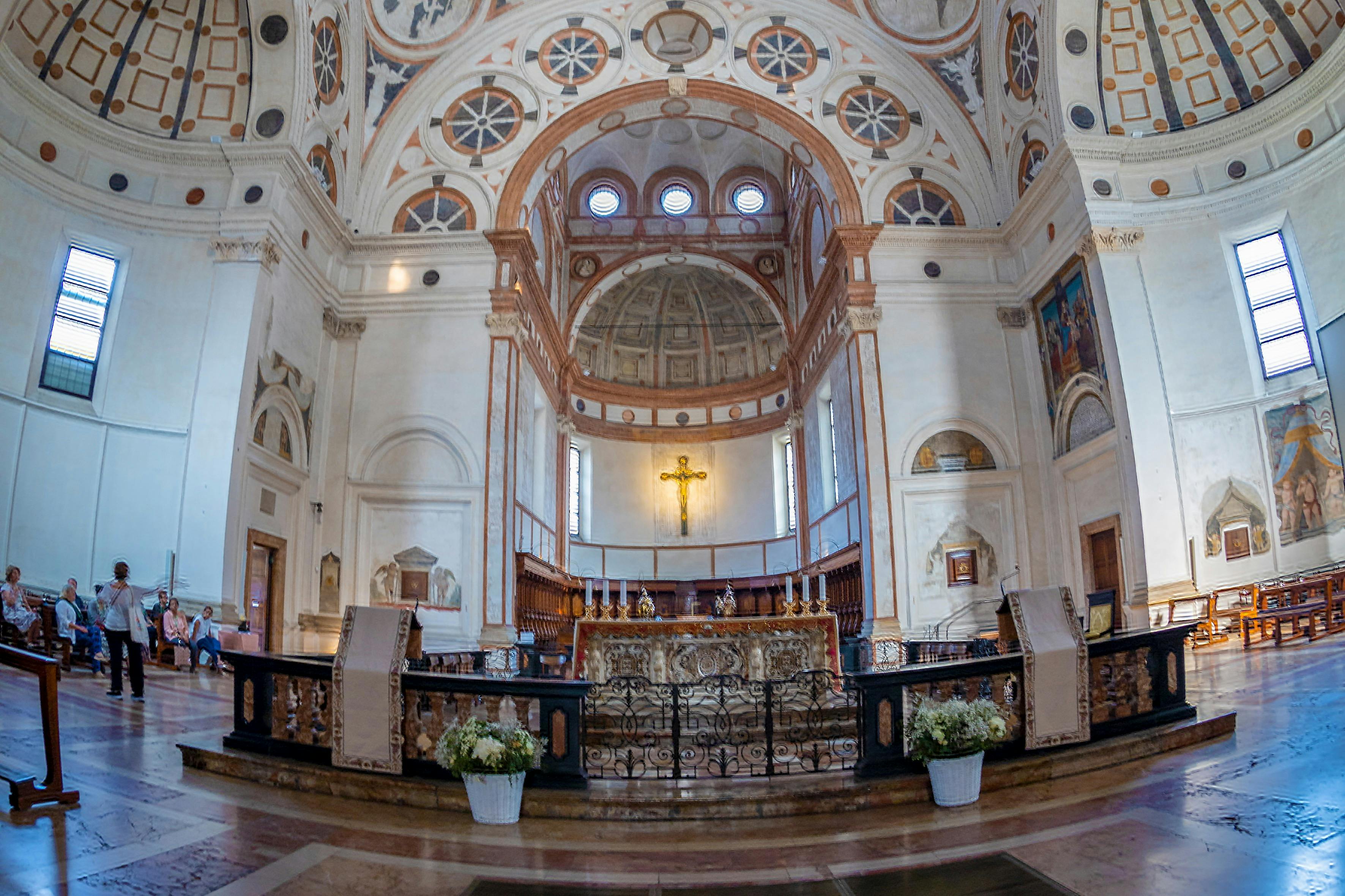 Богато украшенный церковный интерьер с богато украшенным алтарем, золотым распятием, арочными потолками и замысловатыми архитектурными деталями.