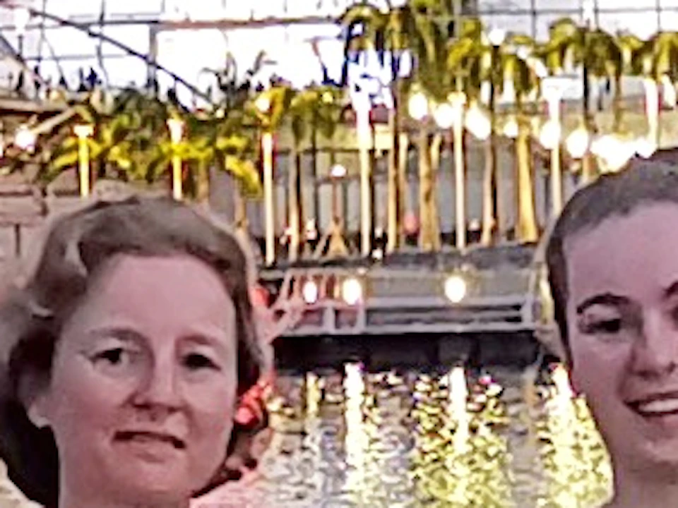 Four people pose in front of Marina Bay Sands and the Helix Bridge in Singapore, illuminated at dusk with a waterfront view.