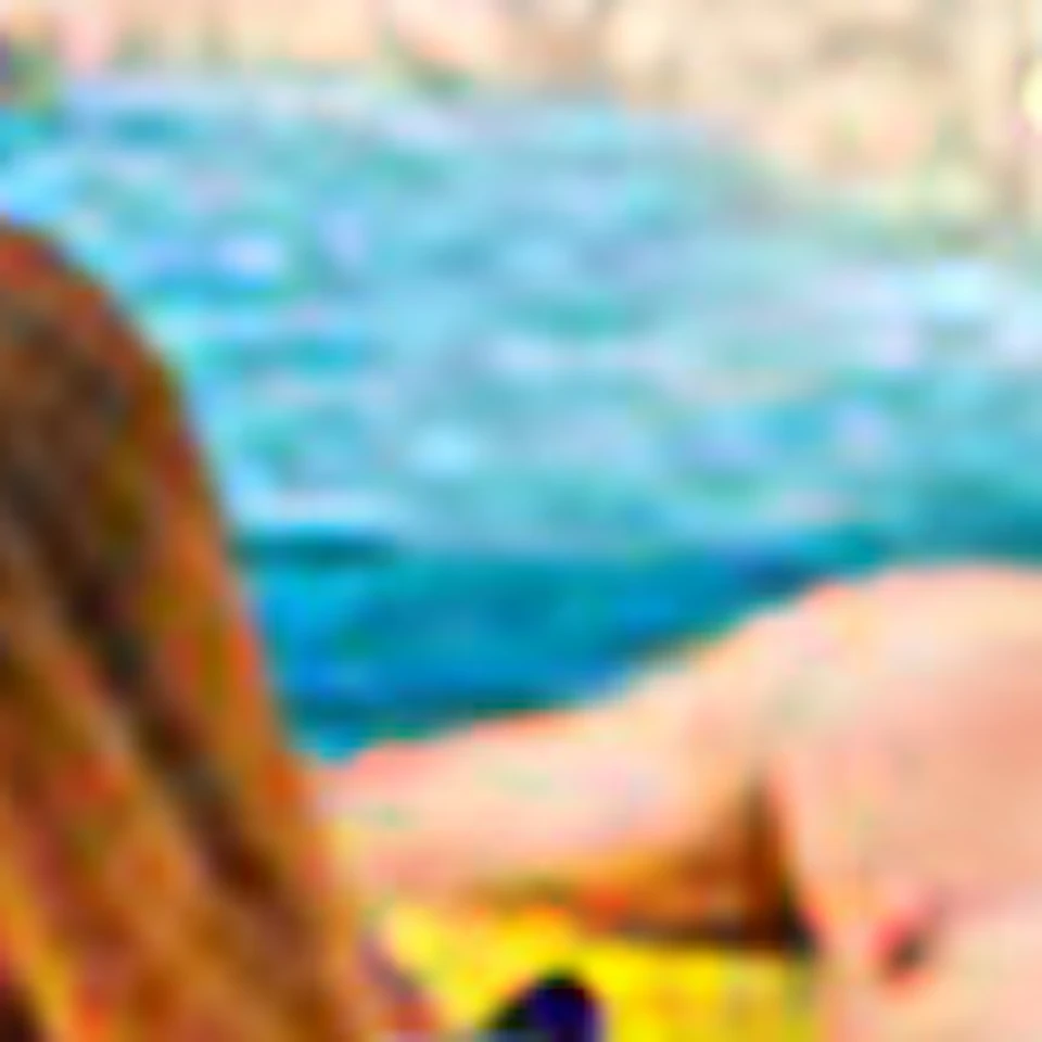 Two people float on yellow inflatable tubes in a lazy river with water slides and ancient ruins in the background.