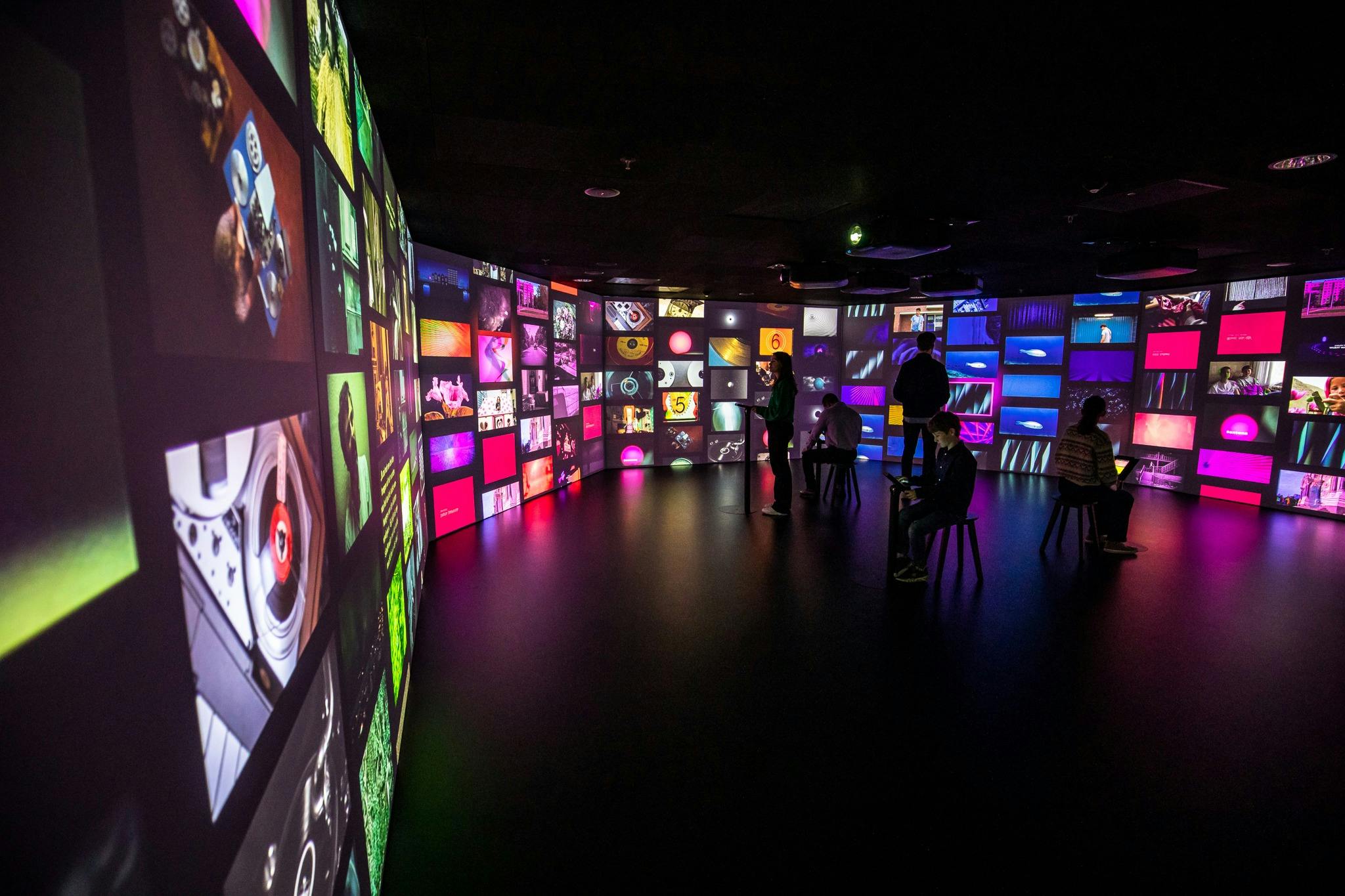 space filled with film images. five people operate a tablet that allows the images to be captured