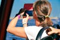 Een passagier in een Hop On-Hop Off bus maakt een foto met haar smartphone.