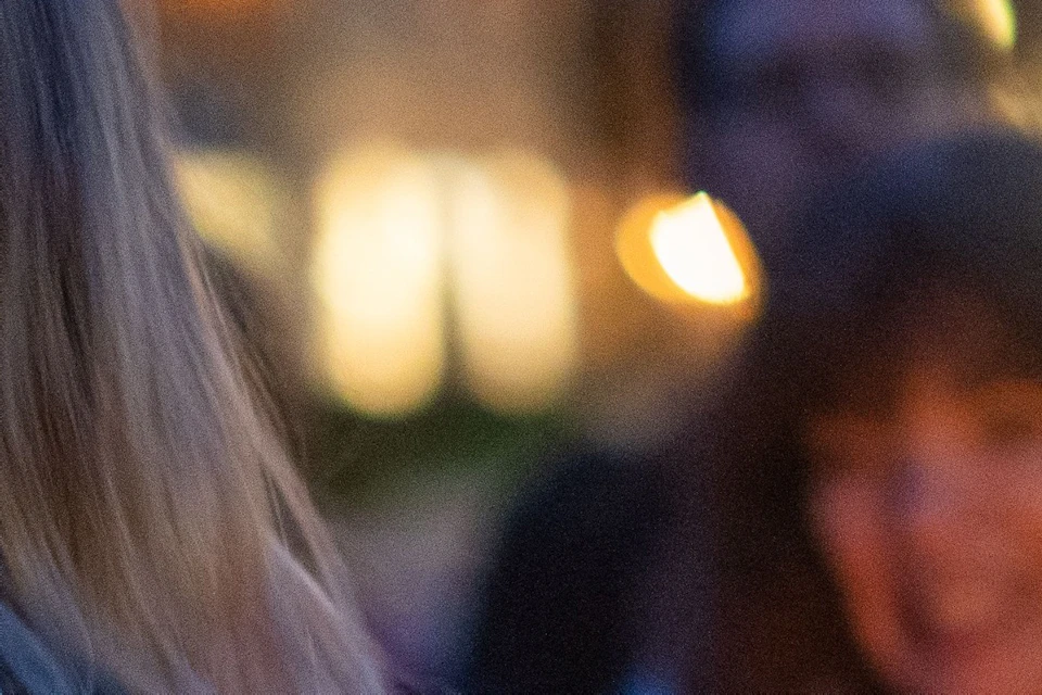 Tour guide holding a lantern as guests surround her to listen to ghost stories