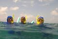 Trois plongeurs avec masque et tuba, avec leur équipement, font une pause paisible, capturant l'essence de la relaxation dans l'exploration sous-marine.