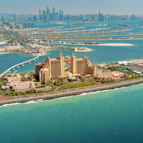 Luftaufnahme des Atlantis, The Palm Hotel mit den umliegenden Wasserstraßen und der entfernten Skyline von Dubai.