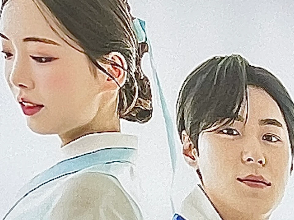A storefront display featuring a poster of two individuals in traditional blue and white Korean hanbok attire.