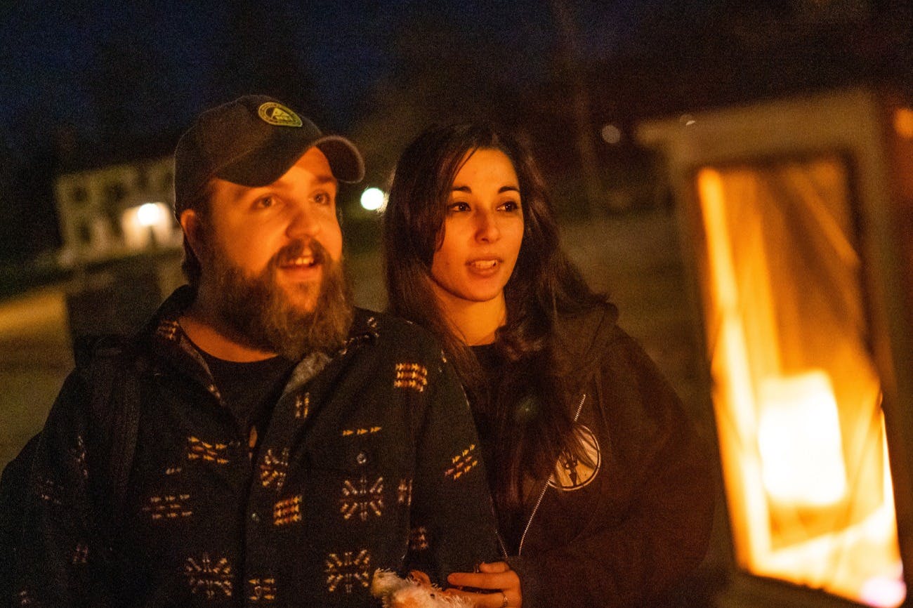 Couple staring into a lantern's glow as they listen to their tour guide