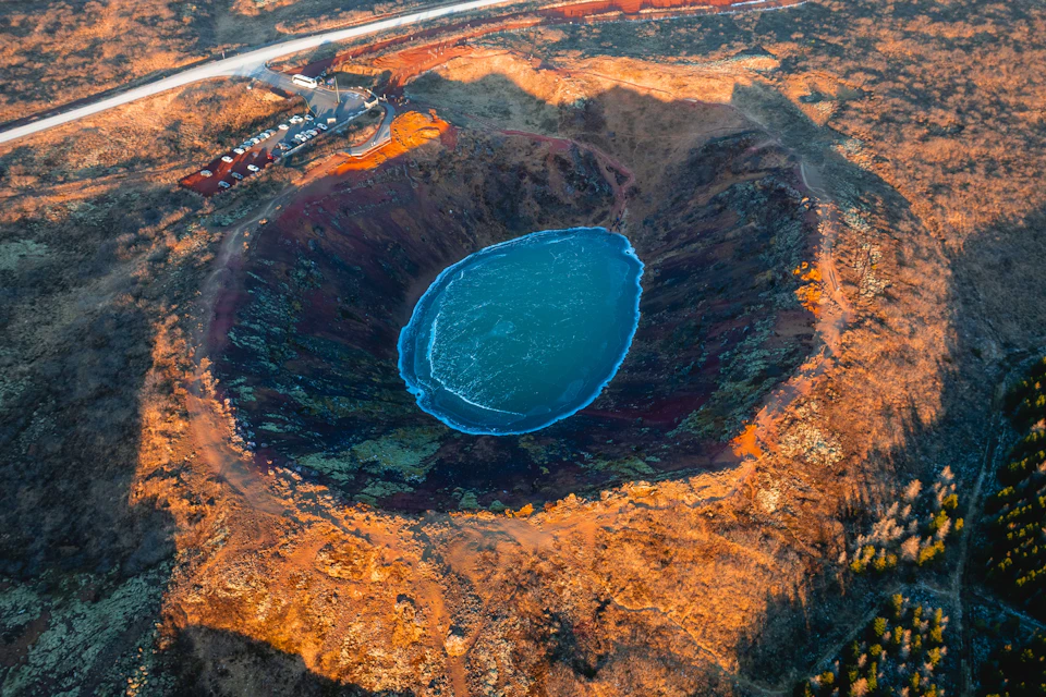 Overhead shot of Kerið Crater in winter, glowing in the orange sun