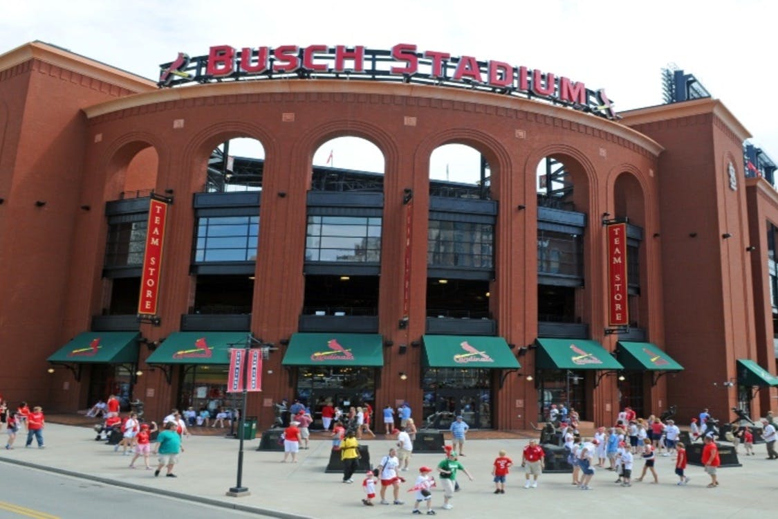 Πλήθος κόσμου έξω από την είσοδο του σταδίου Busch με πράσινες τέντες και πινακίδες "Team Store" κάτω από την τοξωτή πρόσοψη του σταδίου.