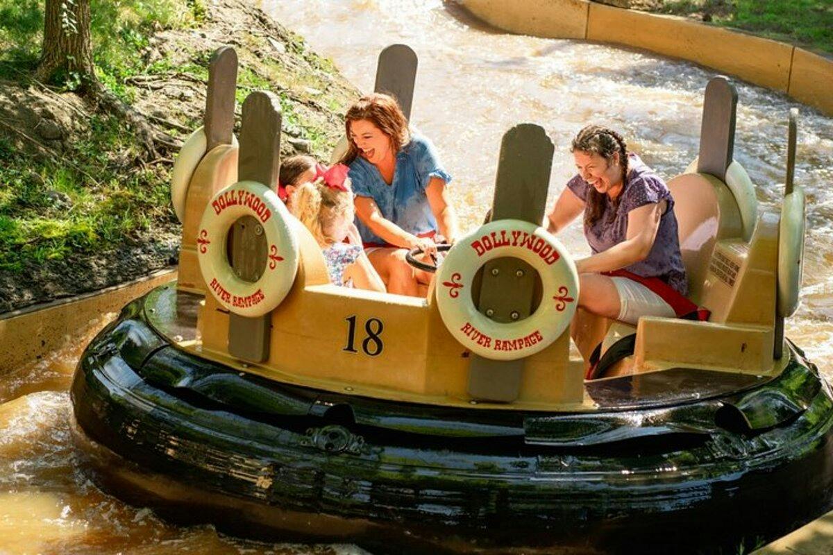People enjoying a water ride at Dollywood, seated in a round raft labeled "River Rampage," surrounded by flowing water.
