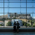 Gasten kijken naar de Akropolis vanuit het Akropolismuseum