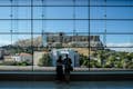 Gäste beobachten die Akropolis vom Akropolismuseum aus