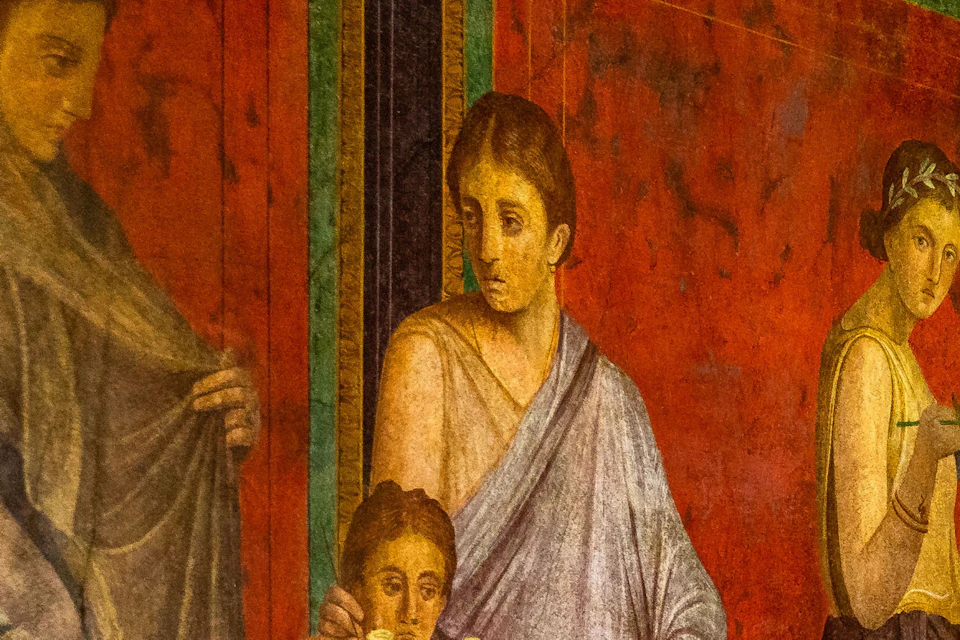 A Roman fresco depicting figures in classical attire, engaged in various activities, on a red and decorated background.