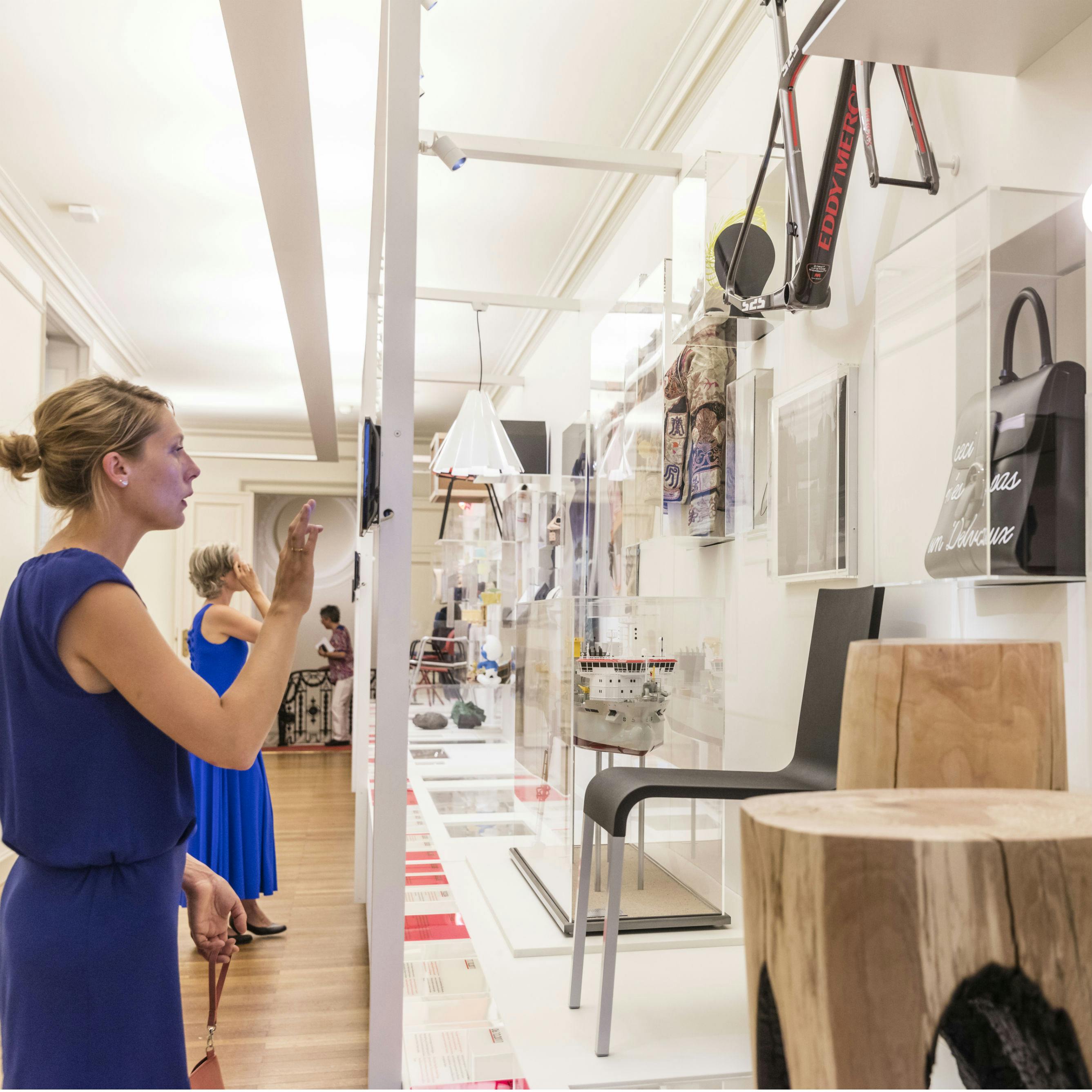 Des visiteurs observent diverses œuvres d&#39;art et expositions dans une galerie de musée moderne et bien éclairée.