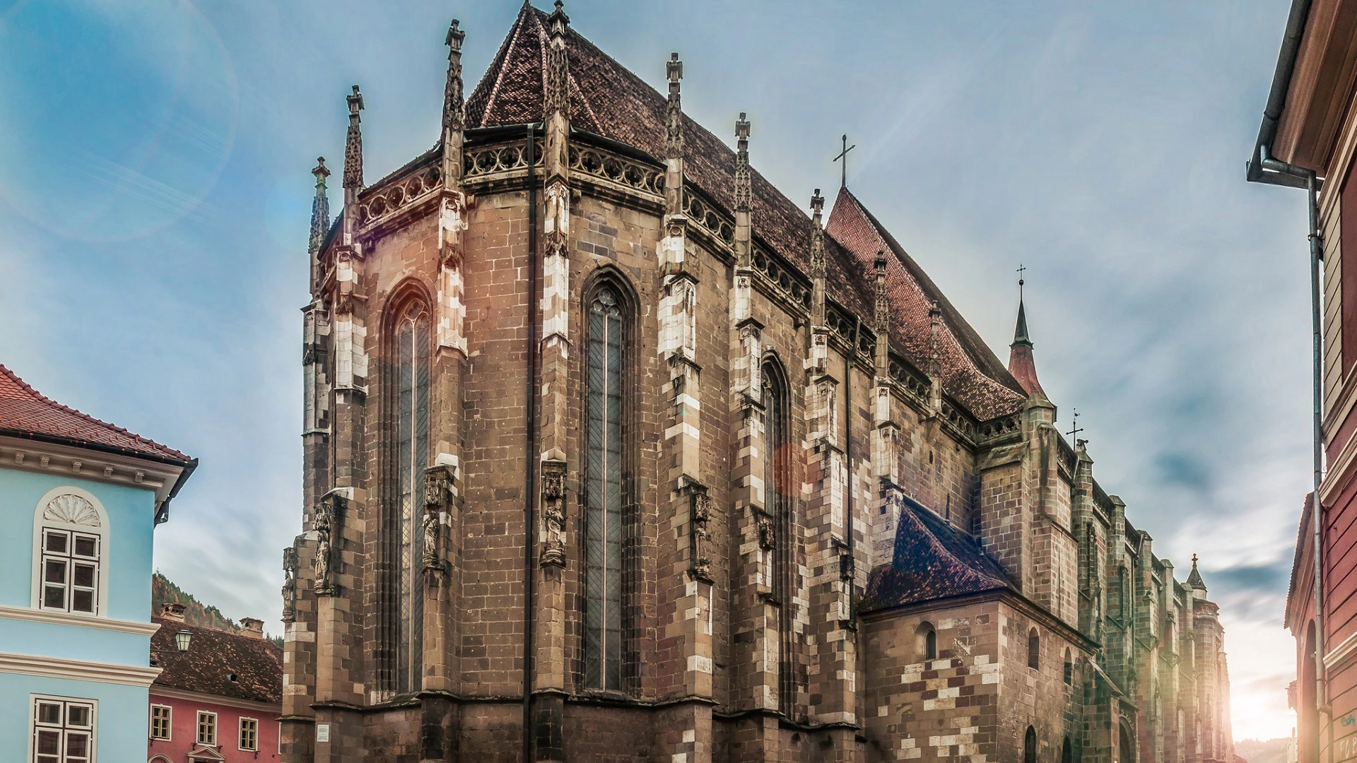 A historic cathedral with Gothic architecture, featuring tall, narrow stained-glass windows and a steep, ornate roof.