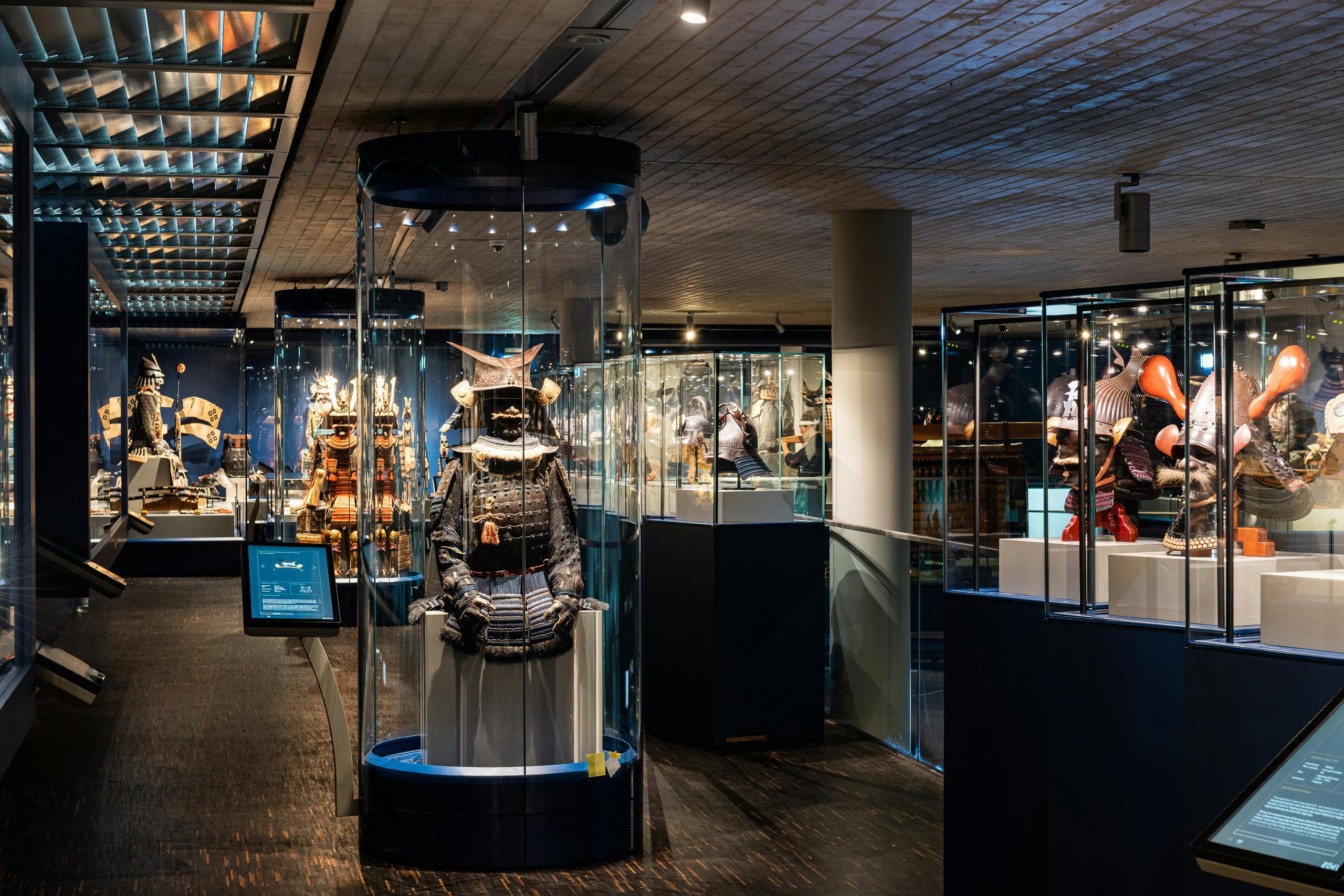 Exhibit of samurai armor and artifacts displayed in glass cases within a modern museum setting.