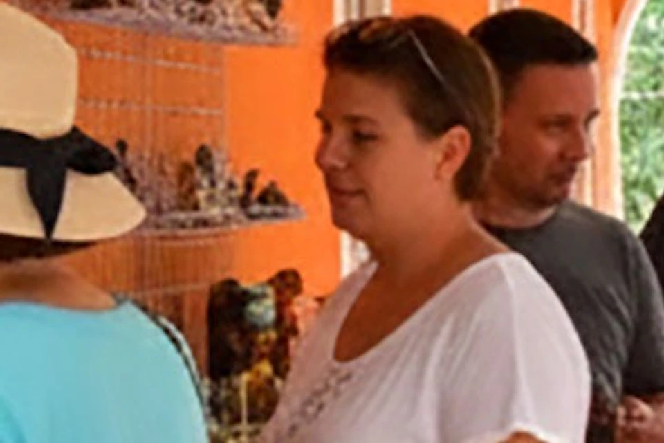 People browsing crafts at a vibrant orange market with colorful decorations and arched architecture.