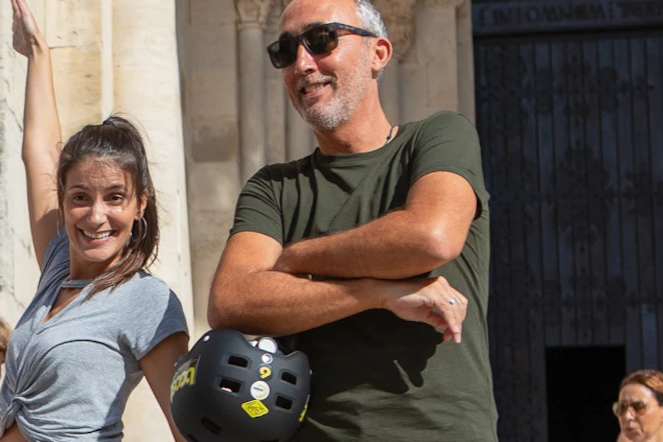 Tourists enjoying an E-Bike Tour in Lisbon with a photo stop at Lisbon Cathedral.