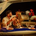 Cena romantica su uno yacht di lusso Coppia che brinda con un bicchiere di vino rosso
