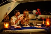 Romantyczna kolacja na luksusowym jachcie Para wznosząca toast kieliszkiem czerwonego wina