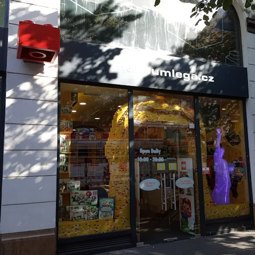 En skyltfönster med en "museumlega.cz" -skylt, med inredning med LEGO-tema och en lila LEGO-staty inuti.