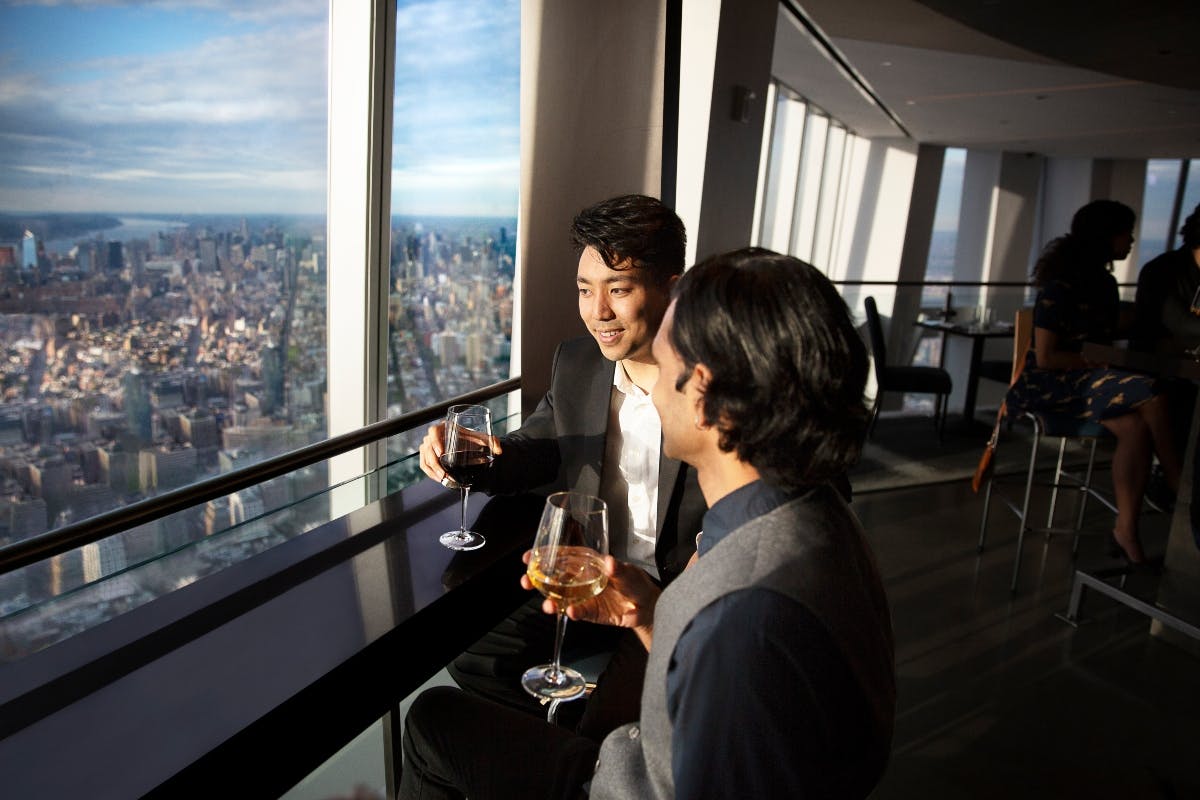 高層レストランでは、大きな窓から街並みが見えるワインを2人で楽しんでいます。
