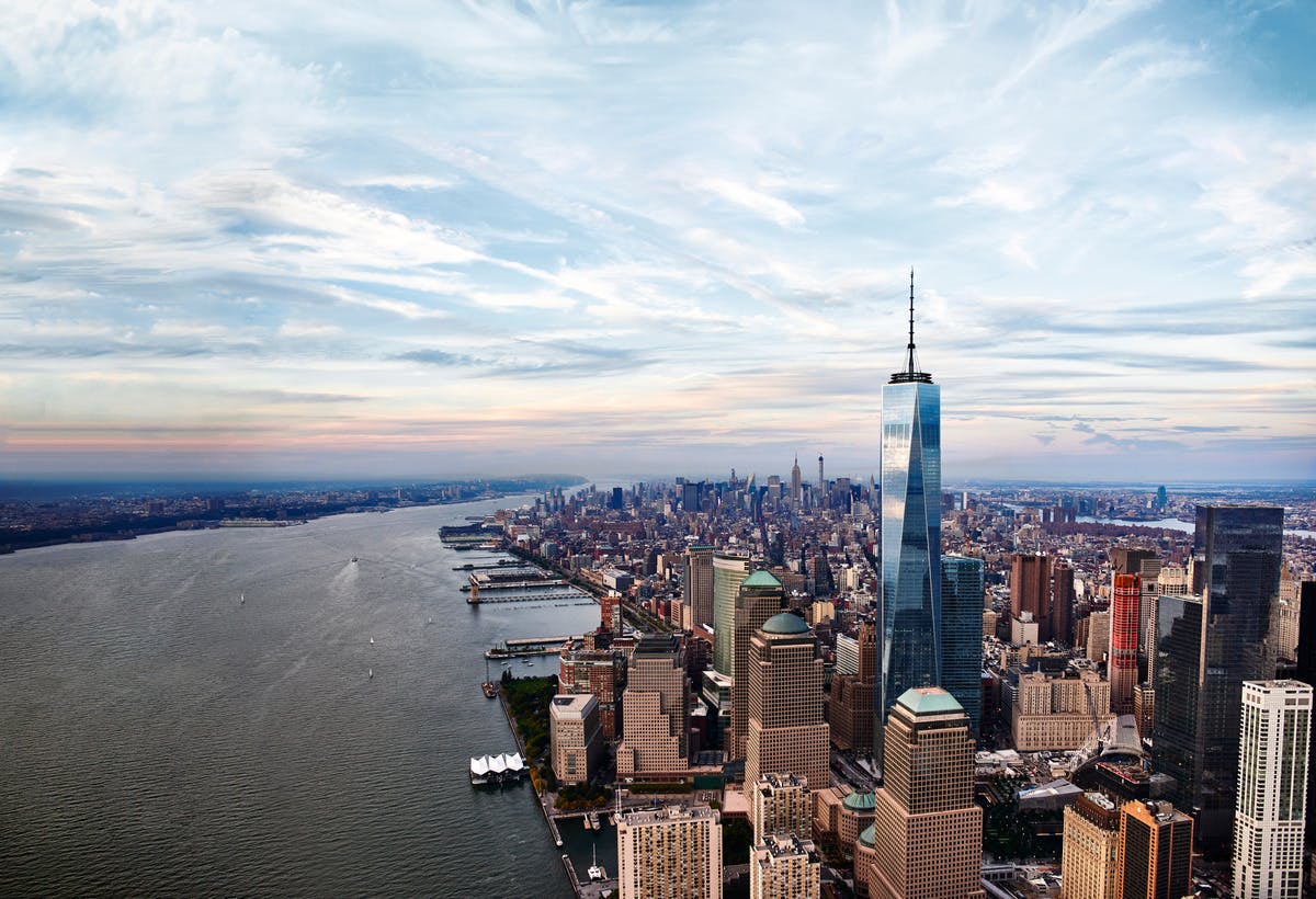 Αεροφωτογραφία του Κάτω Μανχάταν με το One World Trade Center, με τον ποταμό Hudson στα αριστερά κάτω από έναν μερικώς συννεφιασμένο ουρανό.
