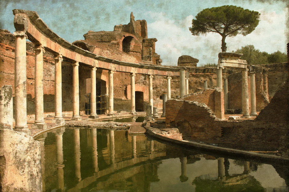 Ancient stone ruins with columns around a still water pool, with a lone tree in the background under a cloudy sky.