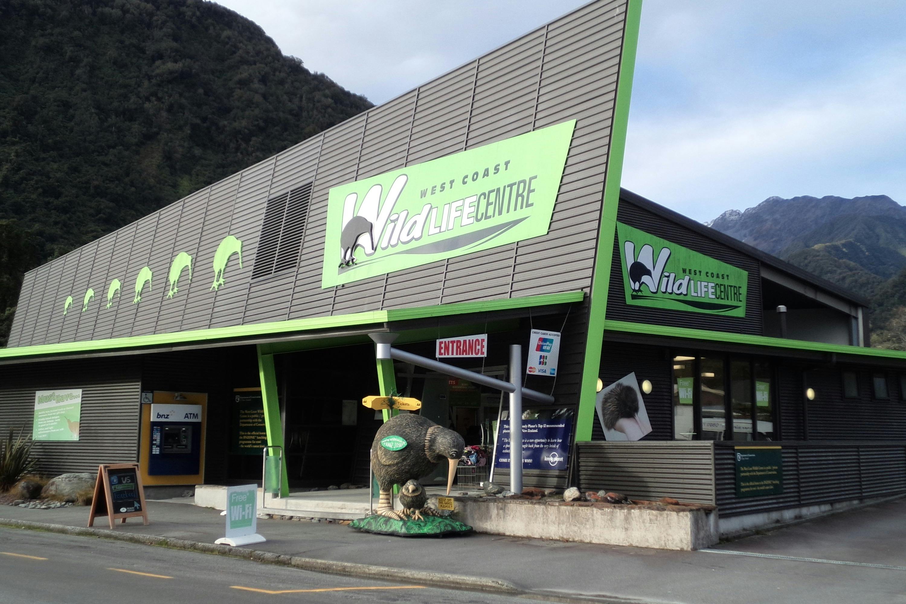 Exterior of the West Coast Wildlife Centre building with a kiwi bird statue and green signage.