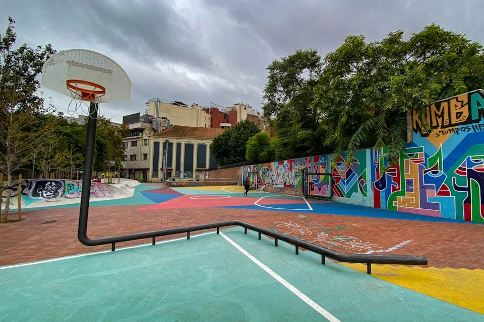 Playground with basketball hoop with street art works on the walls and on the ground.