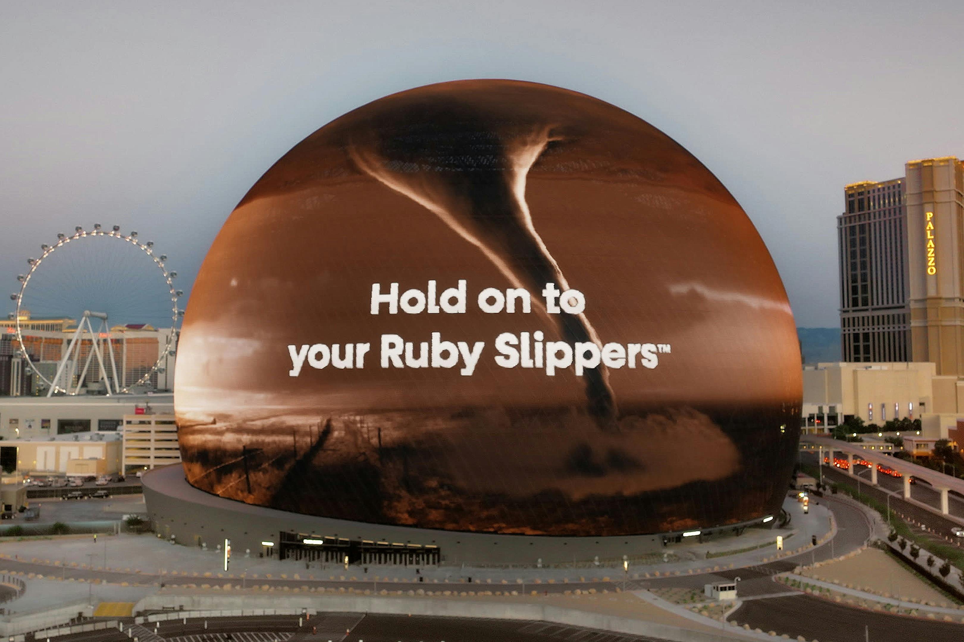一个大型球形屏幕上显示龙卷风，文字为“Hold on to your Ruby Slippers™”。
