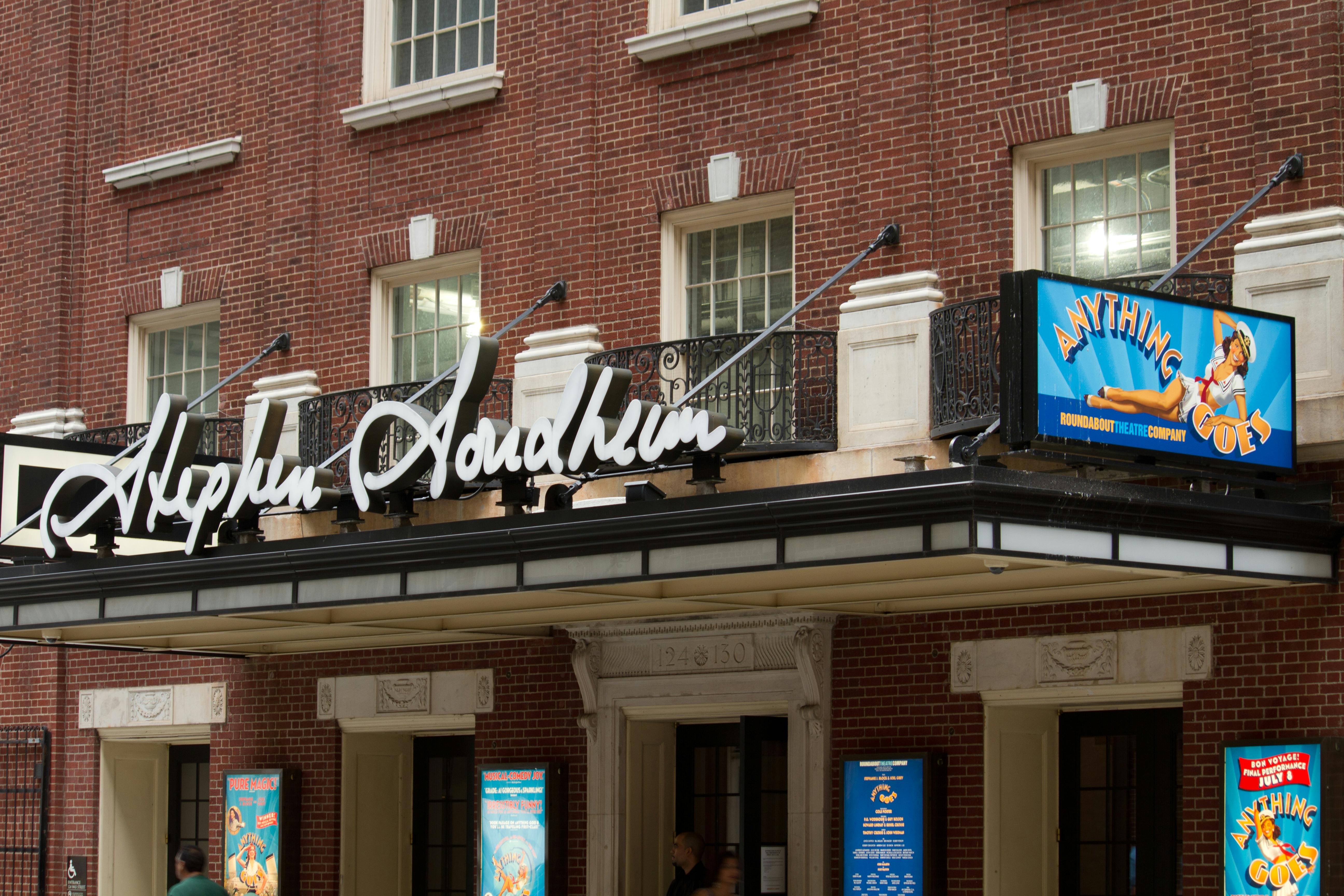 Marquee of Al Hirschfeld Theatre displaying the show "Anything Goes" with colorful posters on a red brick building.