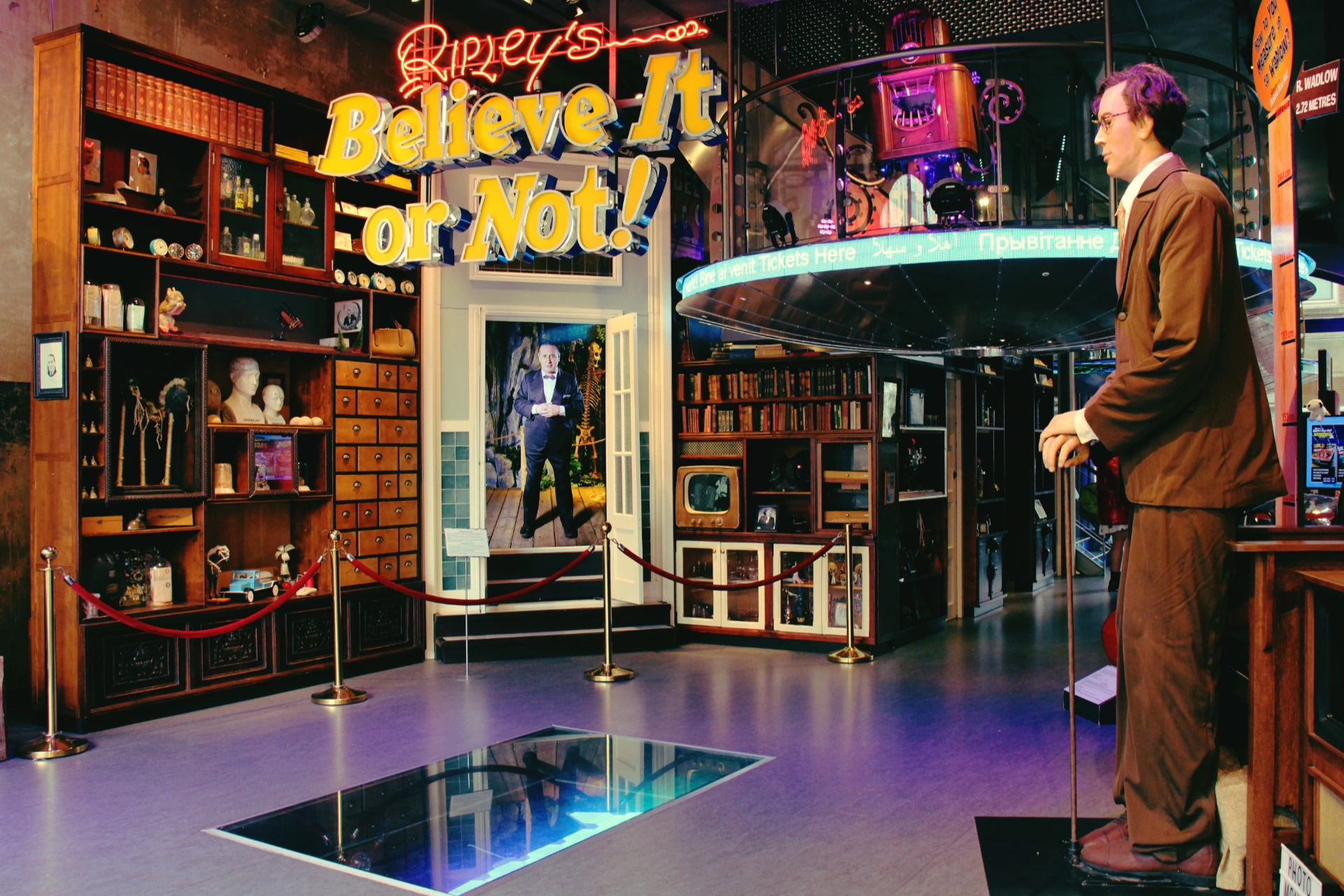 Interior of Ripley's Believe It or Not! museum featuring exhibits, a mannequin of a tall man, and neon signs.